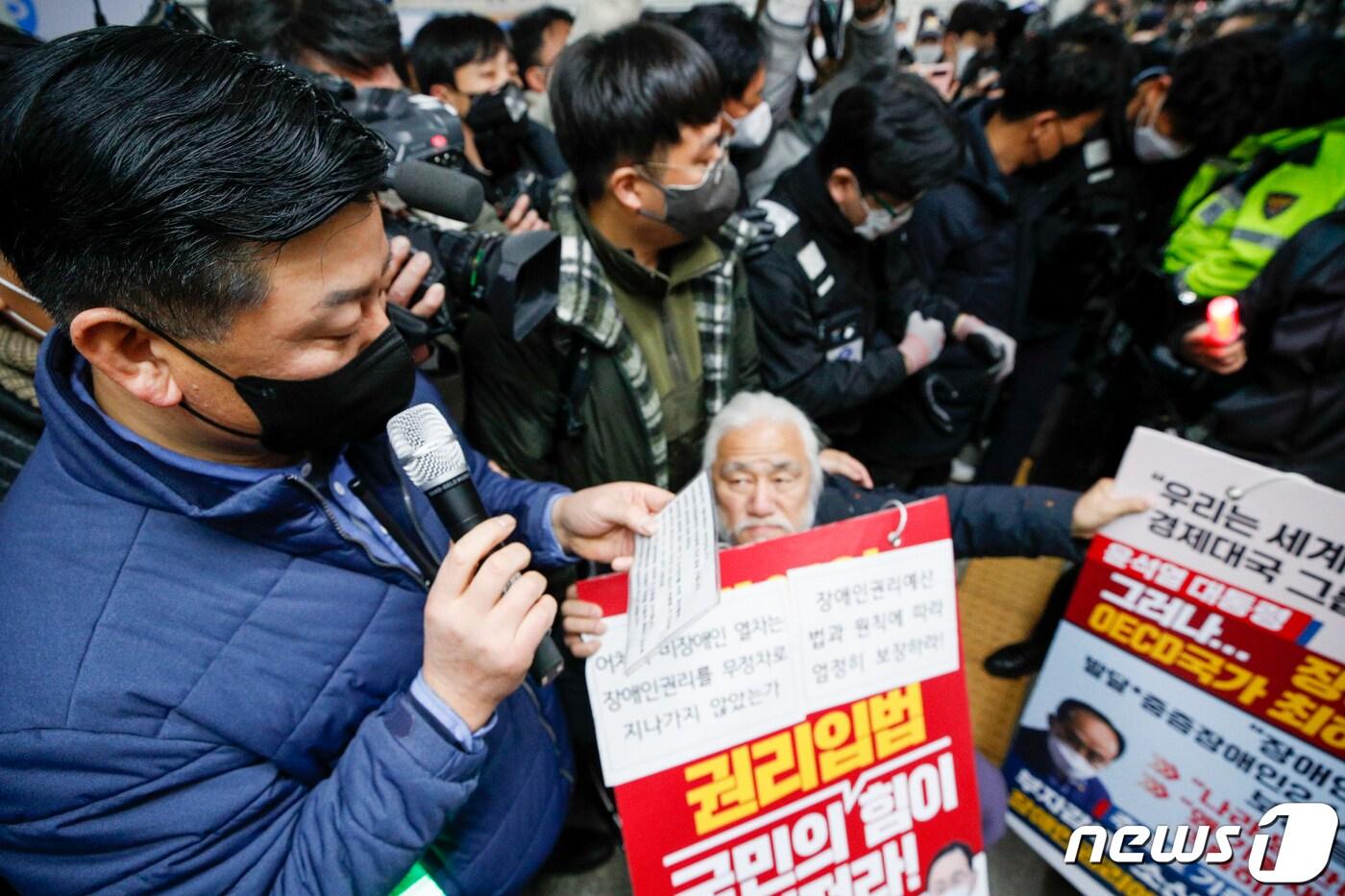 본문 이미지 - 지난달 13일 서울 용산구 삼각지역에서 진행된 전국장애인차별철폐연대 지하철 선전전에서 전장연 회원들과 서울교통공사 측이 대치하고 있다. 2022.12.13/뉴스1 ⓒ News1 김도우 기자