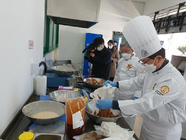 본문 이미지 - 추창민 식품연구소장이 오리 후라이드를 양념소스에 버무리는 모습