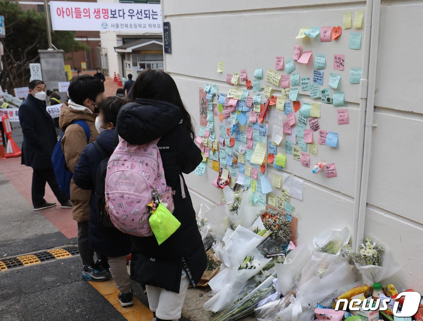 본문 이미지 - 13일 서울 강남의 한 초등학교 앞에 마련된 어린이보호구역(스쿨존)에서 음주 운전 차량에 치어 숨진 초등학생을 기리는 추모 공간에서 학생들이 기도를 하고 있다. 2022.12.13/뉴스1 ⓒ News1 송원영 기자
