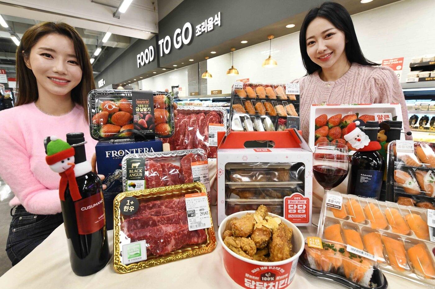 모델들이 크리스마스 홈파티 겨냥 ‘당당 버라이어티 팩'을 비롯한 홈플러스 할인 상품을 소개하는 모습(홈플러스 제공).