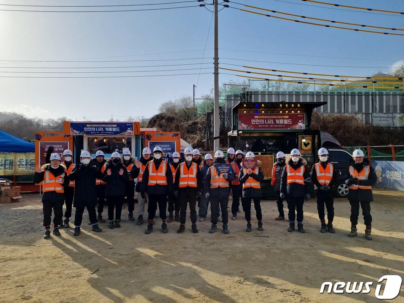 본문 이미지 - 고속국도 14호선 공사현장에서 직원들이 ‘무재해 응원 간식차’ 행사에 앞서 기념사진을 찍고 있다.(계룡건설 제공)