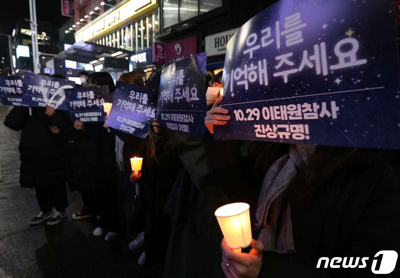 16일 저녁 서울 용산구 이태원역 앞에서 열린 '10.29 이태원 참사 49일 시민추모제'에서 참석자들이 '우리를 기억해 주세요' 손피켓을 들고 있다. 2022.12.16/뉴스1 ⓒ News1 송원영 기자