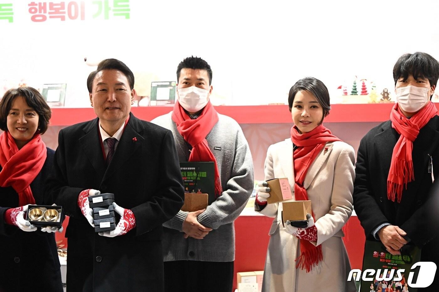 본문 이미지 - 윤석열 대통령과 김건희 여사가 16일 오후 서울 종로구 열린송현녹지광장에서 열린 윈-윈터 페스티벌 개막식에 참석해 소상공인 상품 TOP 10 부스를 둘러보며 지갑, 술잔 등 물건을 구입하고 있다. (대통령실 제공) 2022.12.16/뉴스1 ⓒ News1 안은나 기자