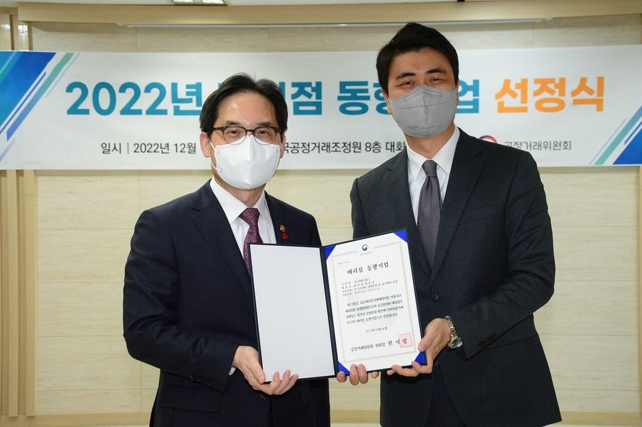 본문 이미지 - (왼쪽부터)한기정 공정거래위원장과 최운식 이랜드월드 대표이사가 선정식 후 기념촬영을 하고 있다.