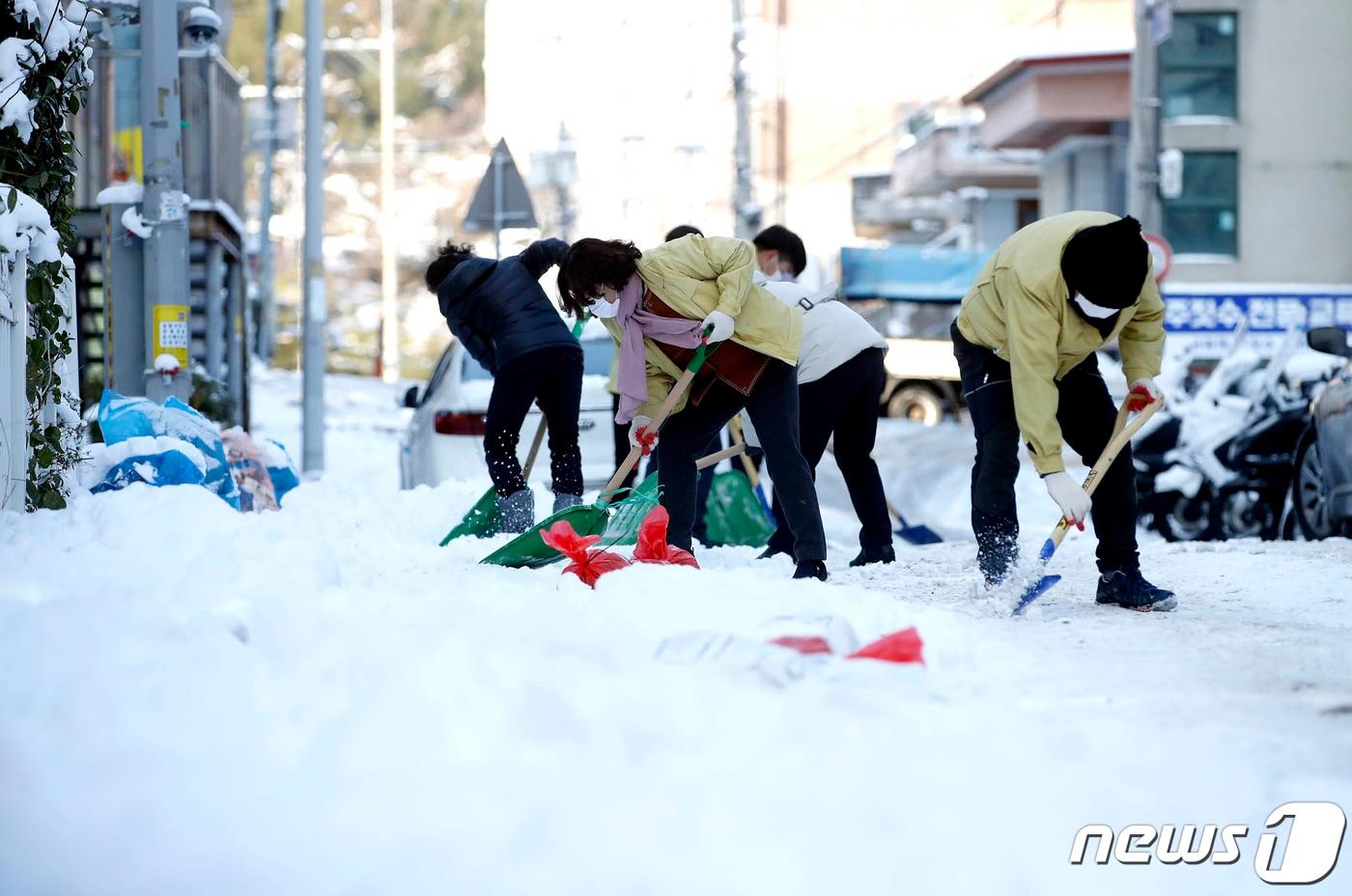 19일 오전 광주 북구 운암1동 주택가 이면도로에서 동행정복지센터 직원들과 통장단들이 모래와 염화칼슘을 뿌리며 제설작업을 하고 있다.(북구 제공)2022.12.19/뉴스1 
