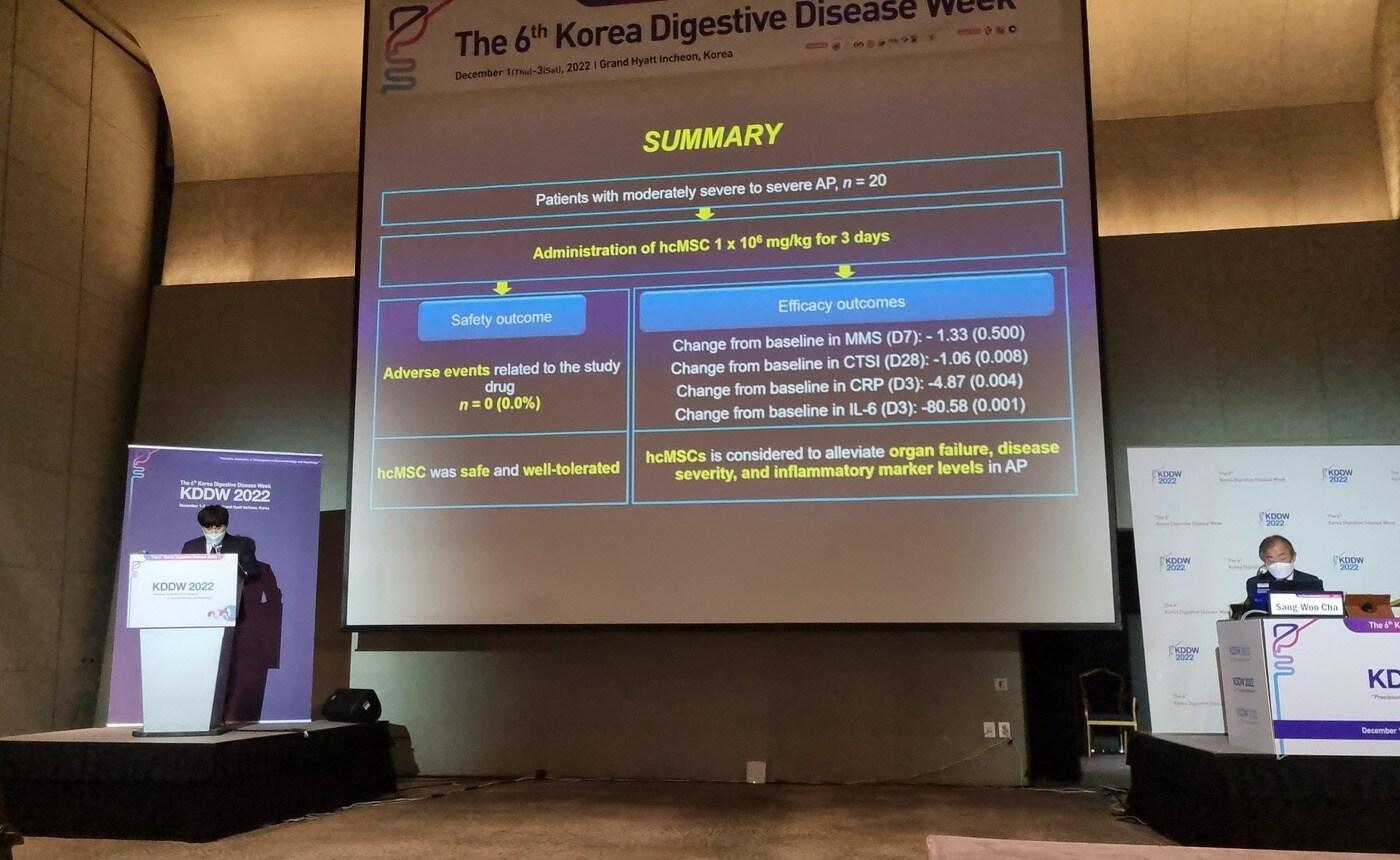 본문 이미지 - 신일상 순천향대학교 부천병원 교수(왼쪽)가 국제소화기학술대회에서 에스씨엠생명과학 급성췌장염 줄기세포치료제 임상2a상 결과를 발표하고 있다(에스씨엠생명과학  제공) 