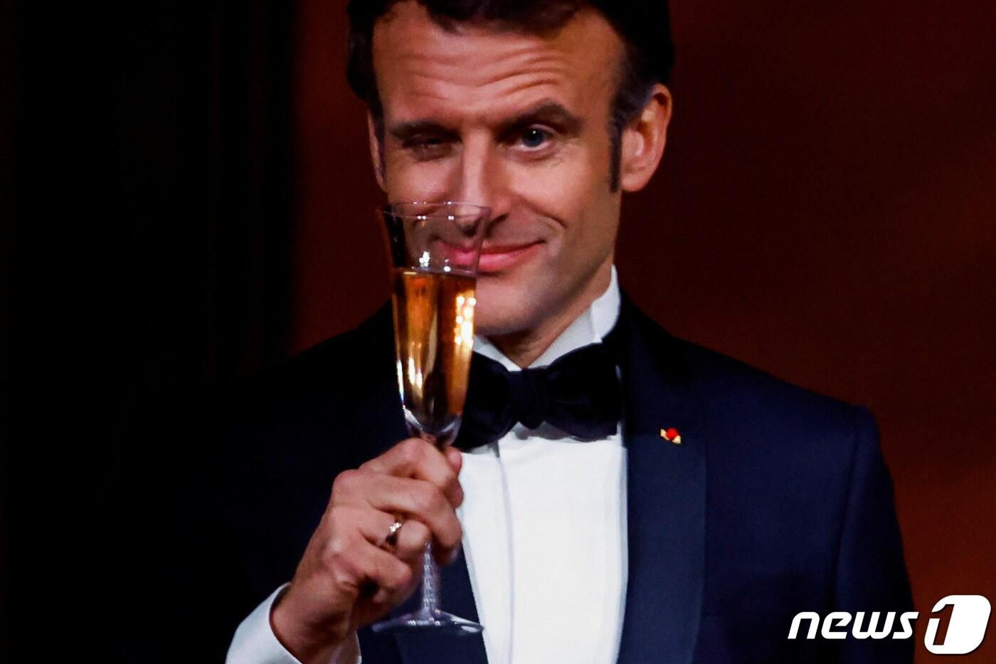 1일(현지시간) 미국 워싱턴 백악관 만찬에서 에마뉘엘 마크롱 프랑스 대통령이 오른쪽 눈을 윙크하며 건배를 하고 있다. ⓒ 로이터=뉴스1 ⓒ News1 권진영 기자
