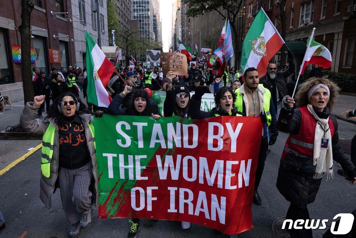 본문 이미지 - 지난 11월19일 미국 뉴욕에서 마샤 아미니의 죽음을 추도하기 시위자들이 국제연합(UN)의 행동을 촉구하고 있다. 이란의 22살 여성 대학생이었던 마샤 아미니는 지난 9월 히잡 사이로 머리카락이 보여 '복장 규정'을 위반했다는 이유로 경찰에 끌려갔다가 숨졌다. ⓒ AFP=뉴스1 ⓒ News1 권진영 기자