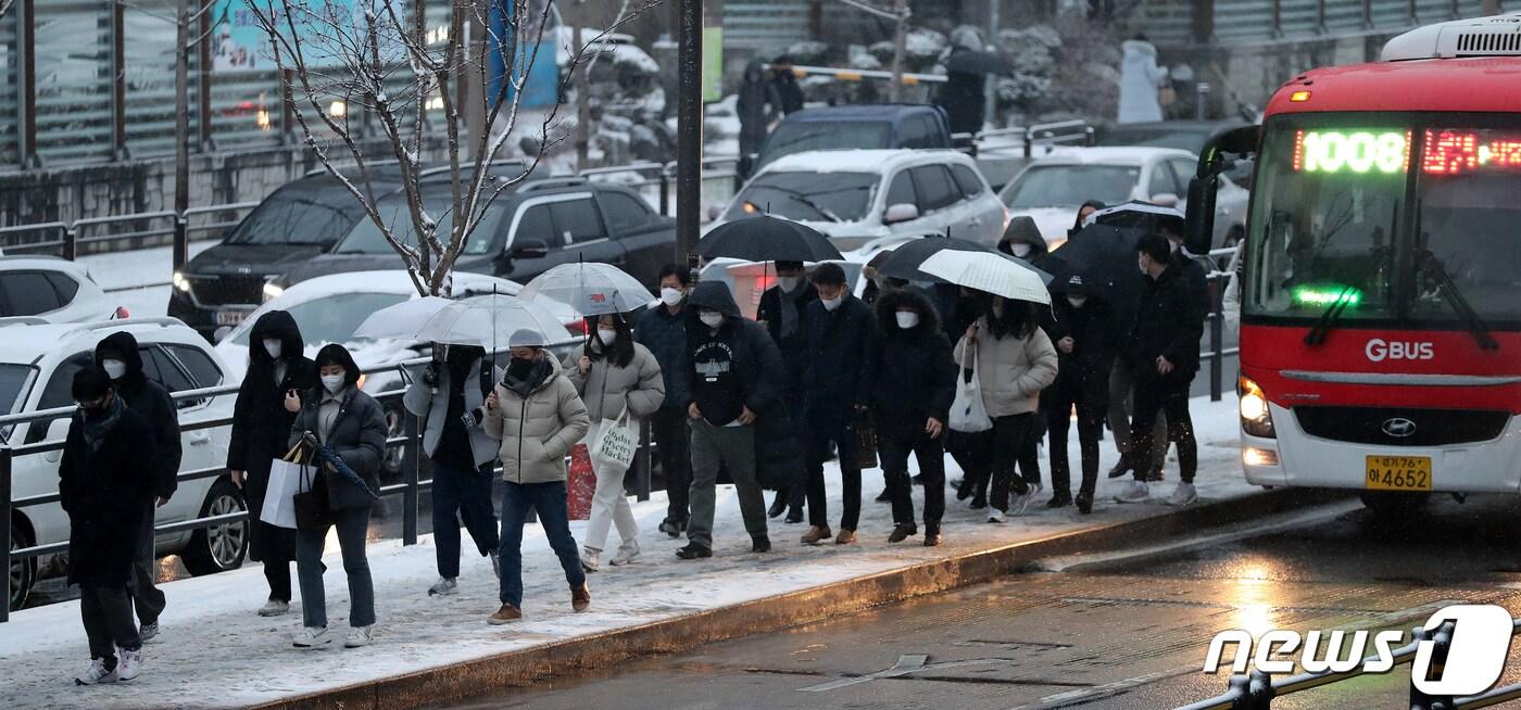 본문 이미지 - 서울을 비롯해 중부지방에 대설특보가 발효된 21일 오전 서울 동작구 사당역 인근 버스정류소에서 시민들이 전철역으로 향하고 있다. 2022.12.21/뉴스1 ⓒ News1 김진환 기자