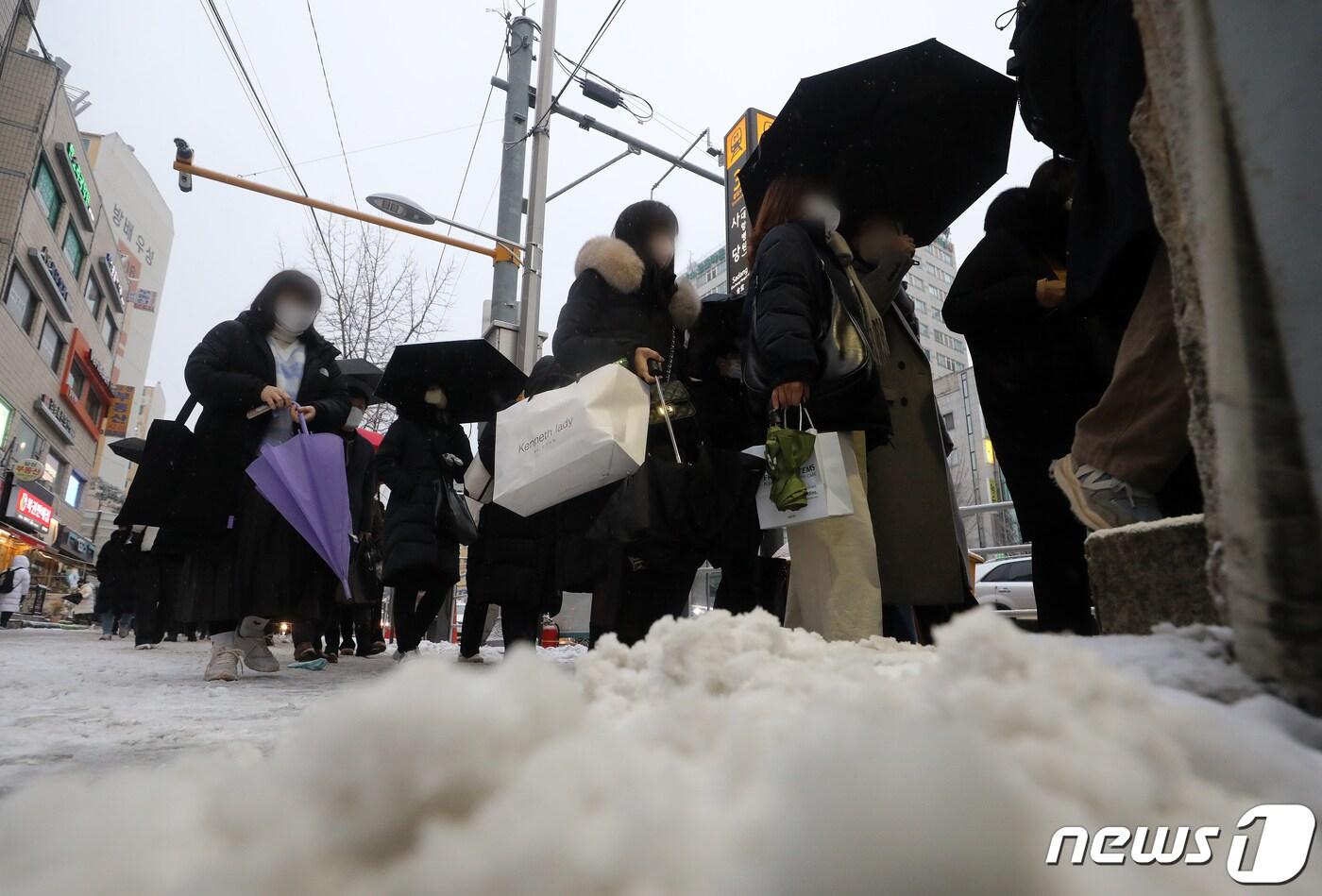 본문 이미지 - 서울을 비롯해 중부지방에 대설특보가 발효된 21일 오전 서울 동작구 사당역 인근 버스정류소에서 시민들이 전철역으로 향하고 있다. 2022.12.21/뉴스1 ⓒ News1 김진환 기자