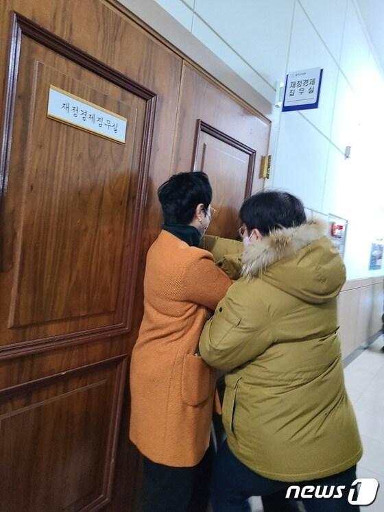 본문 이미지 - 충북 청주시청 본관동 철거에 반대하는 청주시의회 더불어민주당 의원들이 20일 4차 본회의에 참석하려는 같은 당 의원을 재정경제위원회 집무실에 데리고 간 뒤 설득하고 있다. 해당 의원이 집무실을 나오려 하자 민주당 의원들이 문을 막고 있다.2022.12.20/ⓒ 뉴스1 강준식 기자 