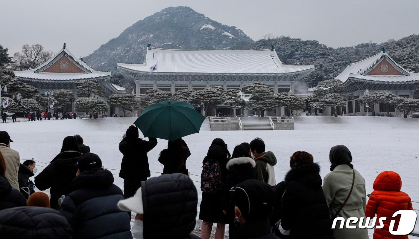 서울을 비롯한 수도권과 중부 지방에 많은 눈이 내린 21일 서울 종로구 청와대를 찾은 관람객들이 눈 쌓인 청와대를 둘러보고 있다. 2022.12.21/뉴스1 ⓒ News1 김도우 기자