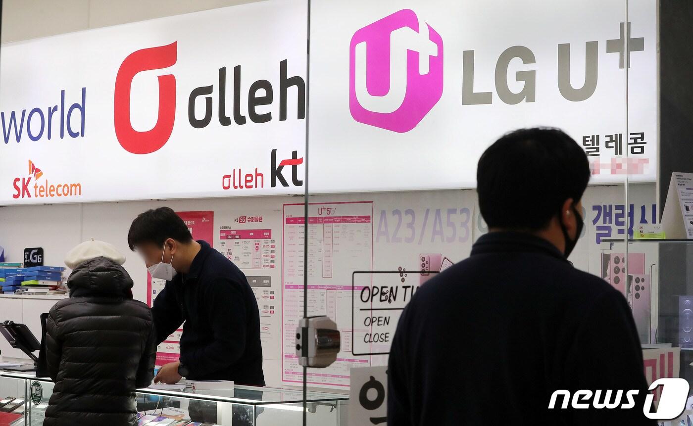 23일 서울 용산의 휴대폰 매장 앞으로 한 시민이 지나가고 있다. 과학기술정보통신부가 이날 KT와 LG유플러스에 대한 5G 28㎓ 대역 주파수 할당 취소를 최종 확정했다. 국내에서 주파수 기간 만료 전 할당이 취소된 첫 사례다. 이번 할당 취소 처분으로 양사의 28㎓ 대역 사용은 이날부로 중단된다. 다만 28㎓ 대역을 활용한 지하철 와이파이는 통신 3사가 공동 구축 및 운영을 이어간다. 2022.12.23/뉴스1 ⓒ News1 박세연 기자