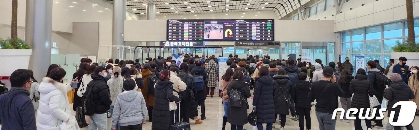 본문 이미지 - 22일부터 제주를 덮친 강풍과 폭설 등으로 끊겼던 제주노선 항공기 운항이 24일 재개되면서 관광객 등이 제주를 떠나기 위해 제주국제공항 국내선 탑승장으로 들어서고 있다.2022.12.24/뉴스1 ⓒ News1 강승남 기자