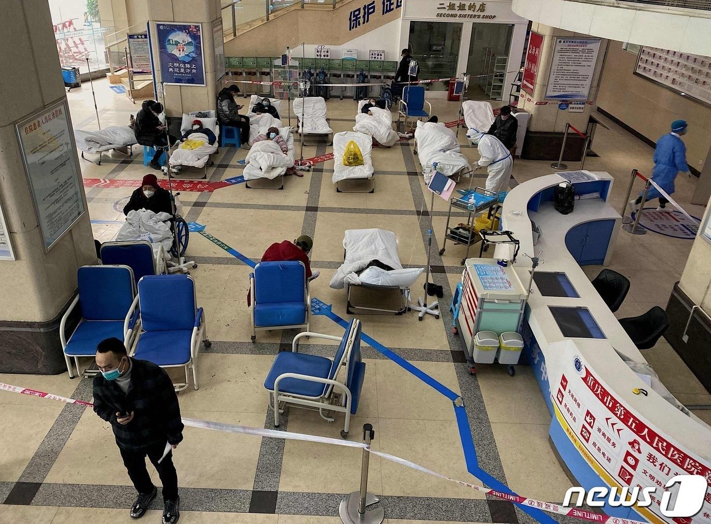 본문 이미지 - 중국 내 코로나19 확진자가 폭증하는 가운데 23일 남서부 충칭시의 제5인민병원이 병상이 모자라 로비에 간이 침대를 펴 놓고 환자를 수용하고 있다. ⓒ AFP=뉴스1 ⓒ News1 강민경 기자