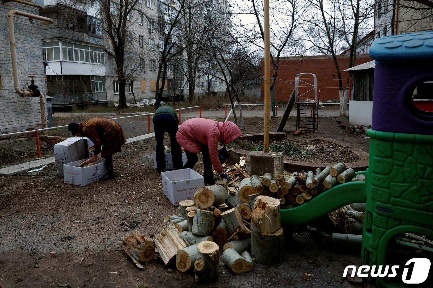 26일(현지시간) 우크라이나 최전방 바흐무트에서 사람들이 땔감으로 쓸 나무를 상자에 채우고 있다. 러시아군의 포격과 격전이 이어지는 가운데 바흐무트 주민들은 혹한기에 전력난을 겪고 있다. ⓒ 로이터=뉴스1 ⓒ News1 권진영 기자