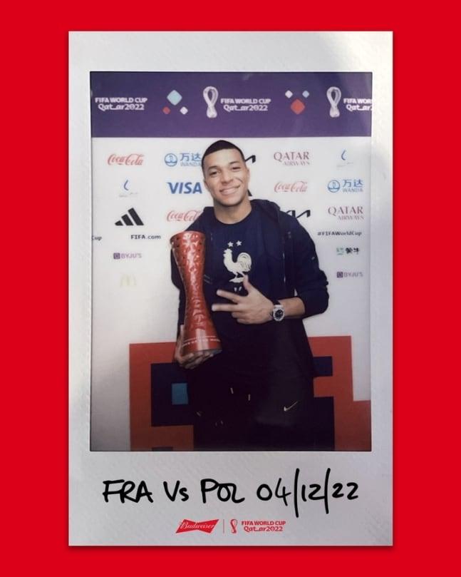 본문 이미지 - 폴란드와 16강전 POTM으로 선정된 음바페는 트로피를 돌려 '버드와이저' 로고를 가린 채 기념사진을 찍었다.(FIFA SNS 캡처)