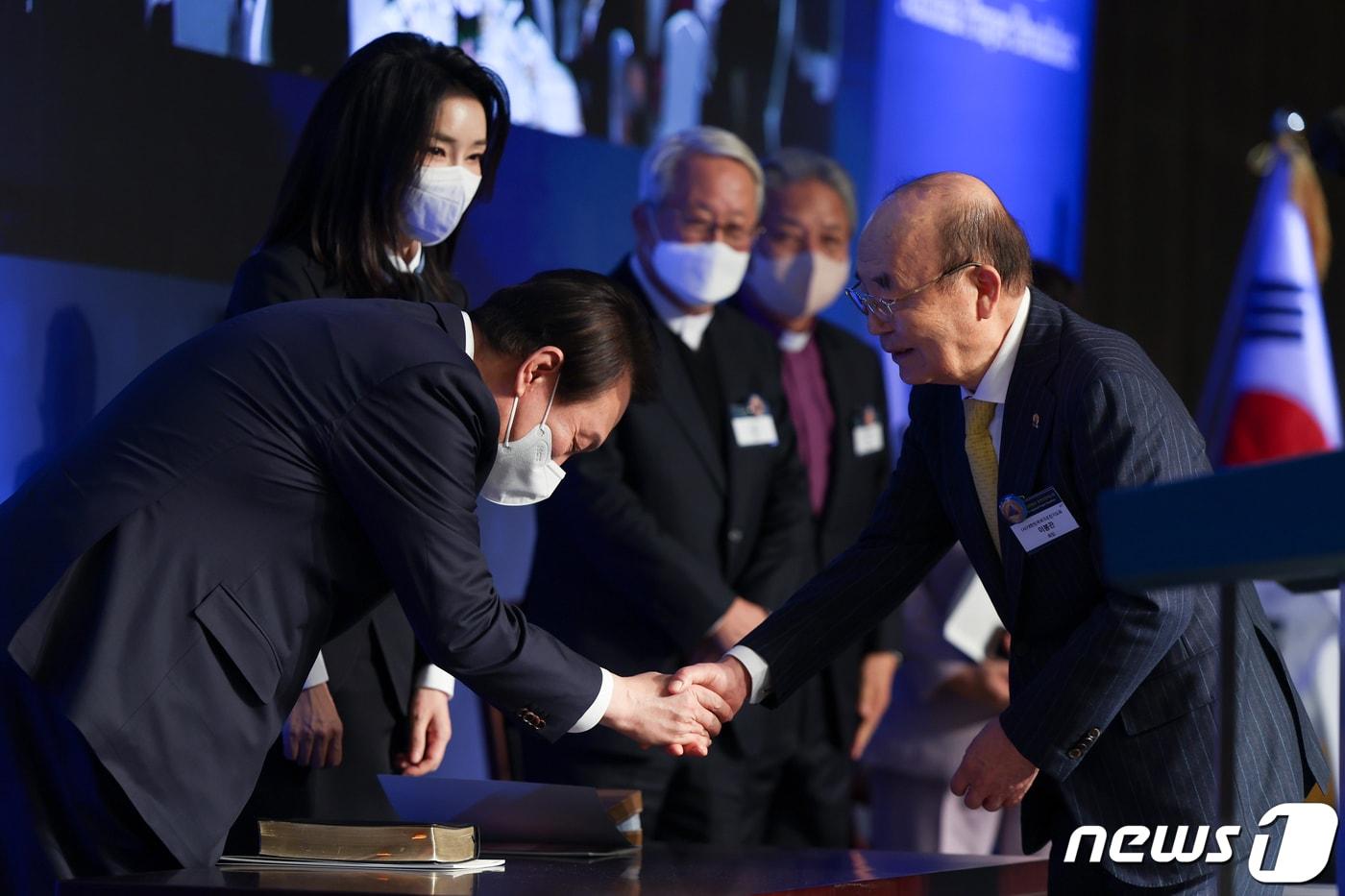 윤석열 대통령 부부가 2022년 12월 5일 서울 강남구 그랜드 인터컨티넨탈 서울파르나스에서 열린 제54회 국가조찬기도회에서 이봉관 국가조찬기도회장(서희건설 회장)과 악수하고 있다. (대통령실 제공) 2022.12.5/뉴스1 ⓒ News1 오대일 기자