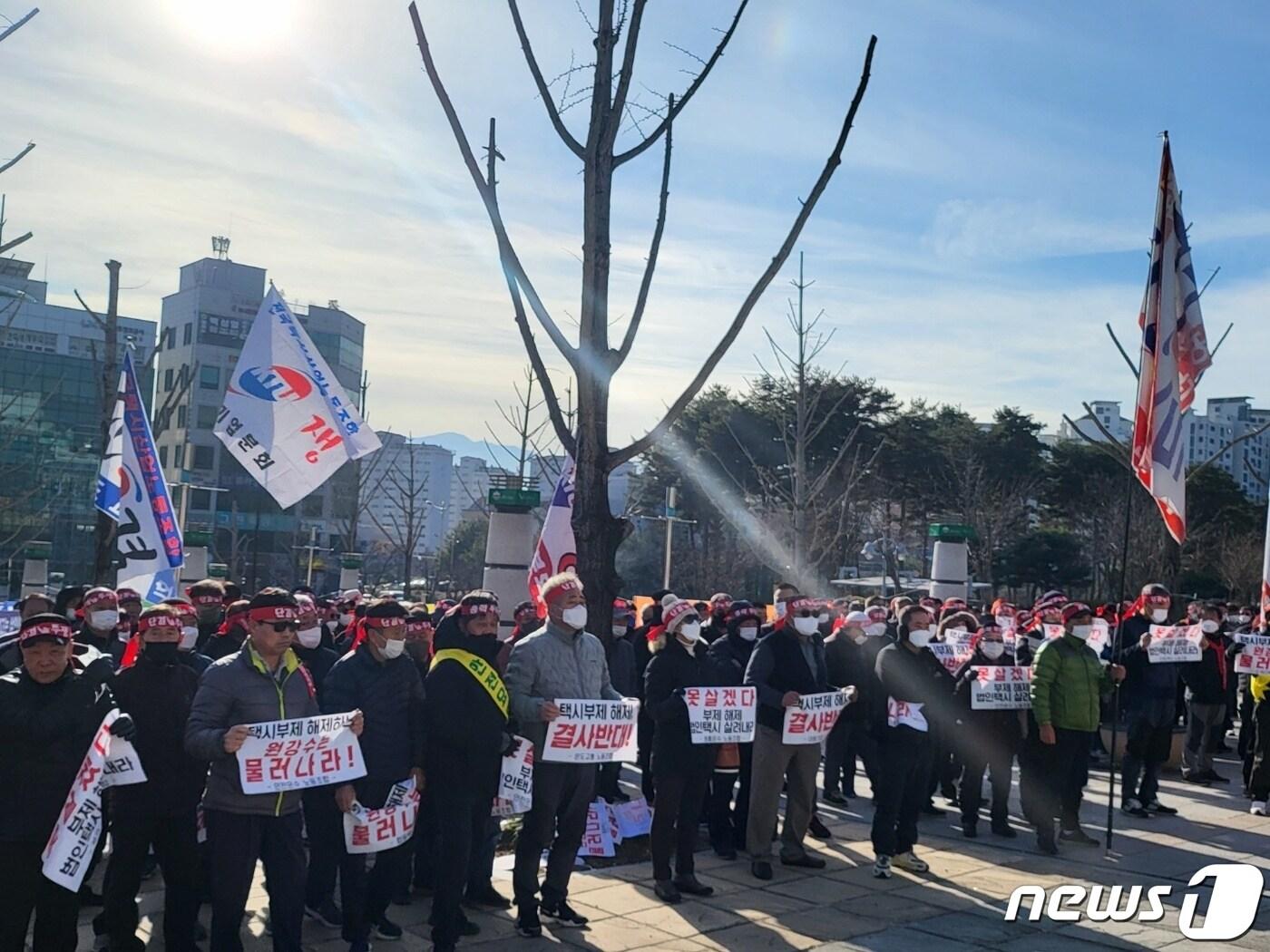 본문 이미지 - 강원 원주지역 14개 법인택시업체 대표자와 근로자들이 5일 시청 앞에서 ‘택시부제 해제 결사반대’ 등의 현수막을 내걸면서 집회에 나서고 있다. 2022.12.5/뉴스1 신관호 기자