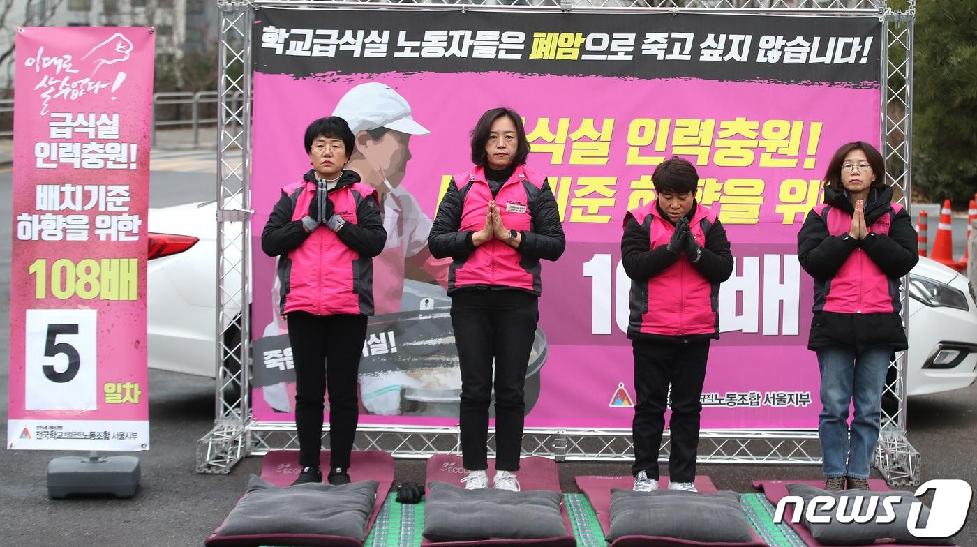 본문 이미지 - 전국학교비정규직노동조합 서울지부 관계자들이 서울교육청 앞에서 급식실 인력 충원·배치기준 하향을 위한 108배에 나서고 있다. 2022.12.9/뉴스1 ⓒ News1 임세영 기자