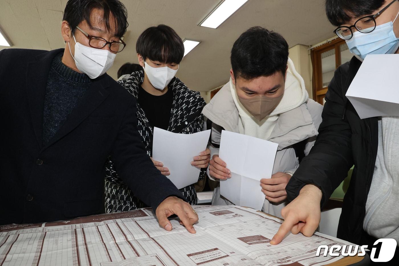 2023학년도 대학수학능력시험 성적표가 배부된 9일 오전 부산 남구 동천고등학교에서 성적표를 받은 고3 수험생들이 지원가능대학학과 참고표수를 확인하고 있다. 2022.12.9/뉴스1 ⓒ News1 김영훈 기자