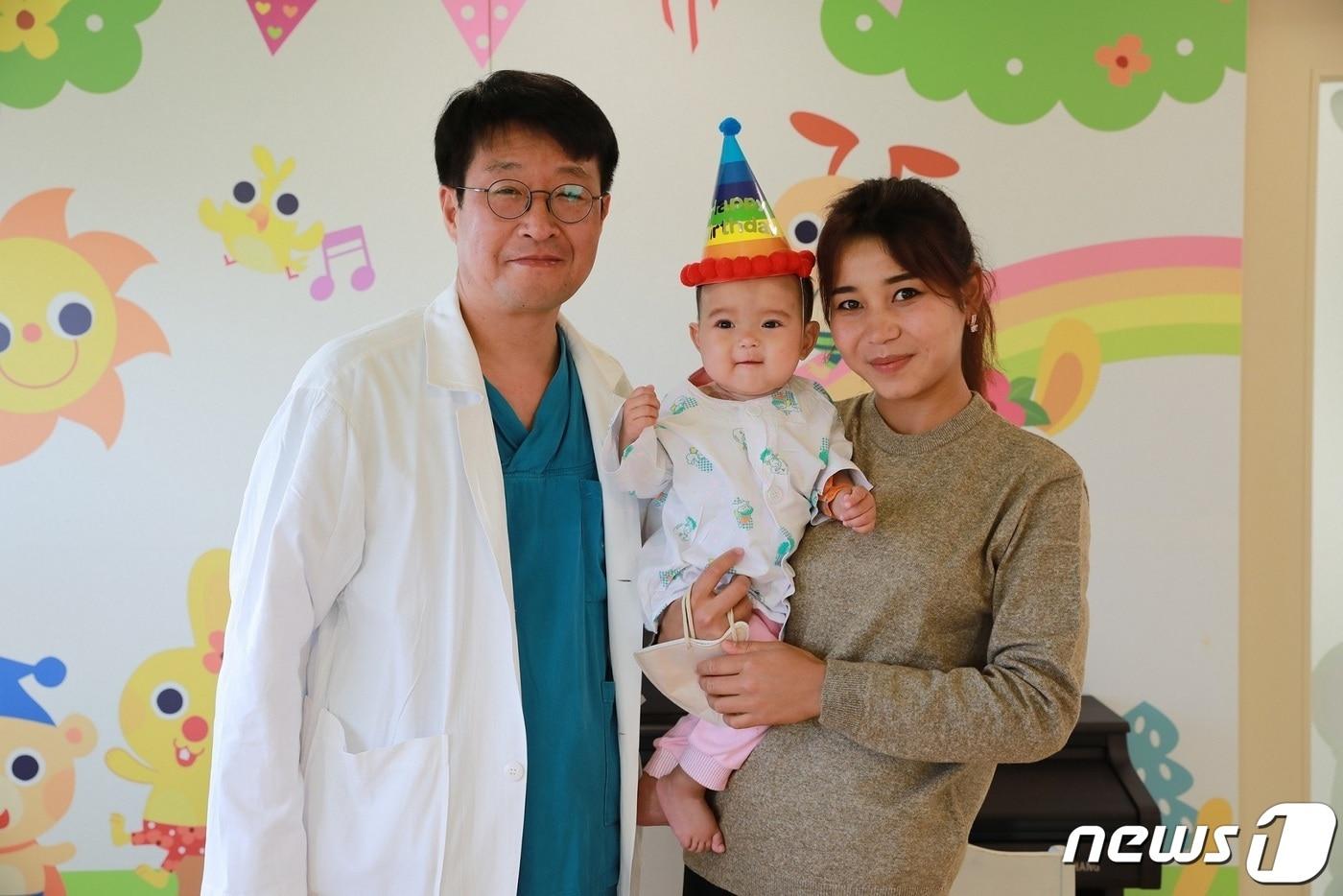 본문 이미지 - 이철 서울성모병원 흉부외과 교수와 우즈베키스탄 환아 바로토바 오이샤오나가 수술 후 기념촬영을 했다.(=서울성모병원 제공.)