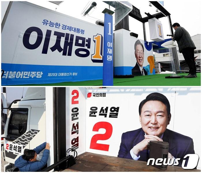 본문 이미지 - 제20대 대통령선거 공식선거운동 개시일을 이틀 앞둔 13일 오후 경기도 파주시에 위치한 차량광고업체에서 관계자들이 이재명 더불어민주당 대선 후보(윗쪽)와 윤석열 국민의힘 대선 후보의 선거유세 차량을 제작·점검하고 있다. 2022.2.13/뉴스1 ⓒ News1 국회사진취재단