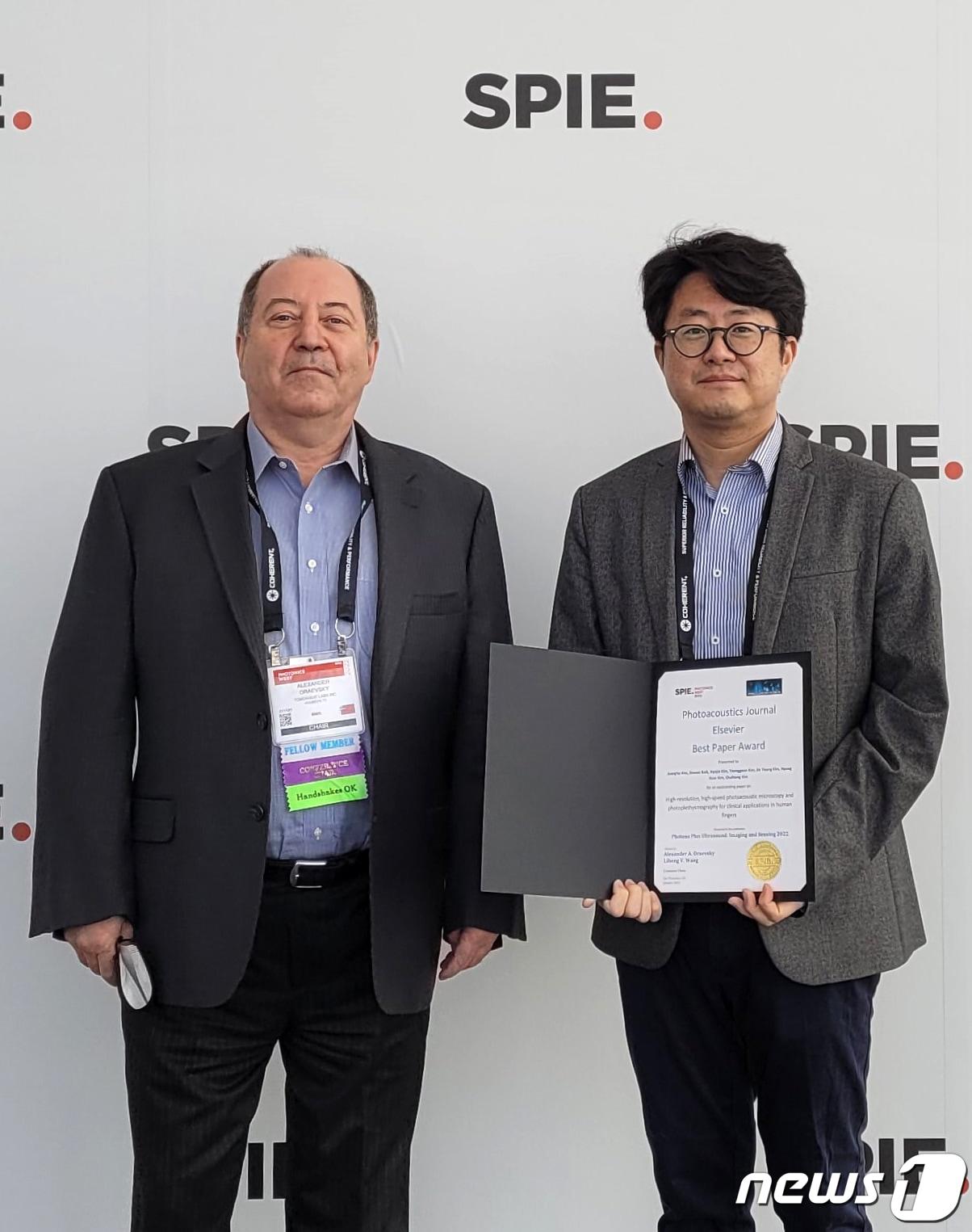 본문 이미지 - 포스텍 IT융합,전자전기, 기계공학과 김철홍 교수와 전자전기 IT융합과 김형함 교수 연구팀이 국제광공학회&#40;SPIE&#41; 최우수 논문상을 수상했다. 김철홍 교수가 학회 관계자로부터 상을 수여받고 있다.&#40;포스텍제공&#41;20222.14/ⓒ 뉴스1
