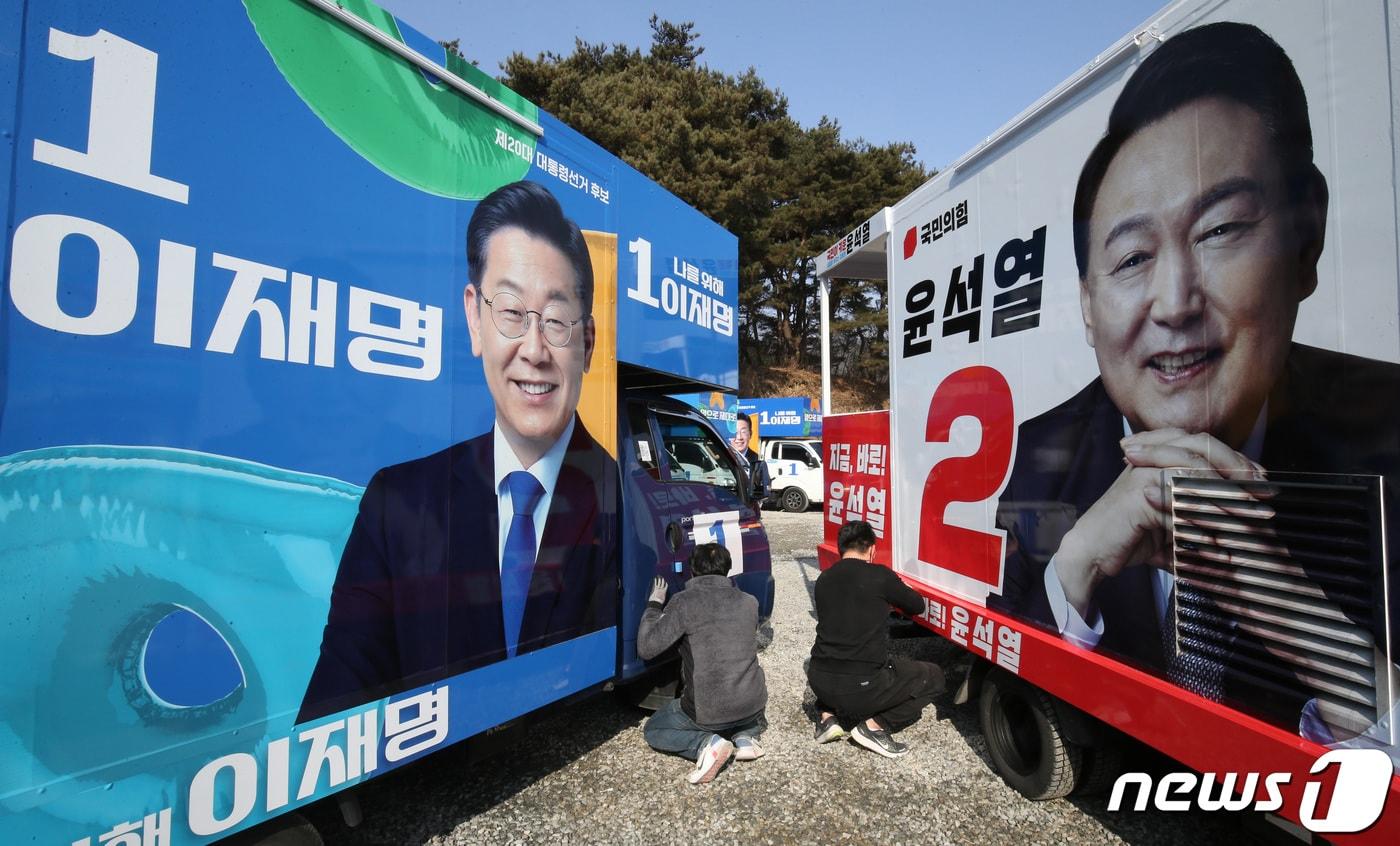 제20대 대통령선거 공식선거운동을 앞둔 14일 충남 금산에 위치한 차량광고업체에서 관계자들이 이재명 더불어민주당 대선 후보와 윤석열 국민의힘 대전 후보의 선거운동 유세차량을 제작하고 있다. 2022.2.14/뉴스1 ⓒ News1 김기태 기자