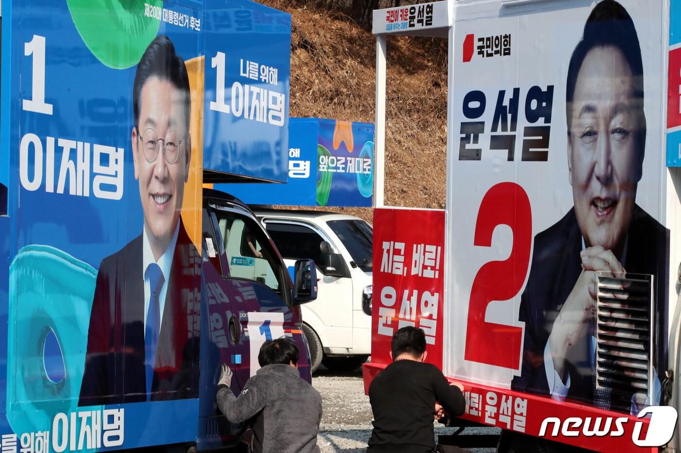 본문 이미지 - 제20대 대통령선거 공식선거운동을 앞둔 14일 충남 금산에 위치한 차량광고업체에서 관계자들이 이재명 더불어민주당 대선 후보와 윤석열 국민의힘 대전 후보의 선거운동 유세차량을 제작하고 있다. 2022.2.14/뉴스1 ⓒ News1 김기태 기자