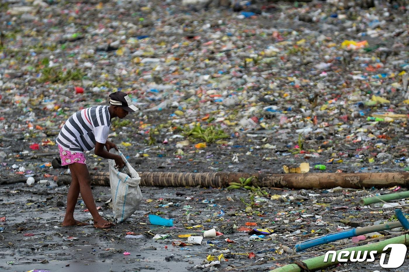 필리핀 마닐라의 파시그 강둑에서 한 여성이 플라스틱 컵을 줍고 있다. (자료 사진) 2021.06.10. ⓒ 로이터=뉴스1 ⓒ News1 김민수 기자