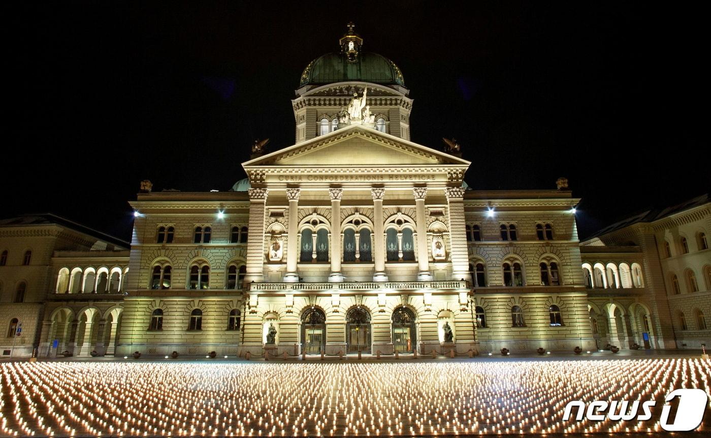 지난 2021년 12월 7일 스위스 베른 분데스하우스 앞에 코로나19 사망자를 기리는 초 1만1000여 개가 밝혀졌다. 당시 1만1000여 명이던 스위스의 누적 사망자 수는 2022년 2월 17일 기준 1만3000여 명으로 늘었다. ⓒ 로이터=뉴스1 ⓒ News1 최서윤 기자