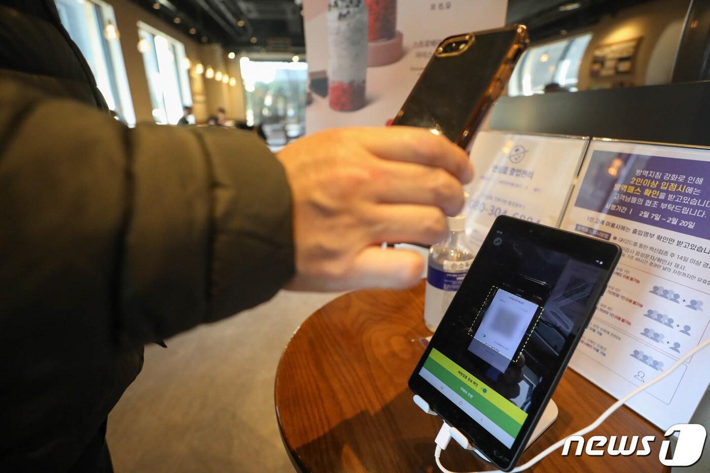 18일 서울 강남의 한 카페에서 시민들이 입장 전 QR코드를 찍고 있다. 2022.2.18/뉴스1 ⓒ News1 성동훈 기자