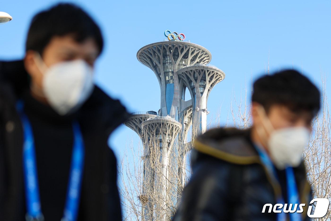본문 이미지 - 2022 베이징 동계올림픽 개막을 이틀 앞둔 2일 중국 베이징 메인 미디어센터 앞에서 올림픽 타워를 배경으로 취재진이 지나가고 있다. 2022.2.2/뉴스1 ⓒ News1 안은나 기자