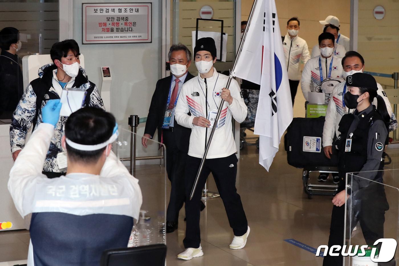 본문 이미지 - 2022 베이징 동계올림픽 여정을 마무리한 대한민국 선수단 본진이 21일 오후 인천국제공항 제2여객터미널을 통해 귀국하자 방역 관계자들이 손을 들어 안내하고 있다. 우리나라는 금메달 2개, 은메달 5개, 동메달 2개를 따내며 종합 14위를 기록했다. 2022.2.21/뉴스1 ⓒ News1 민경석 기자