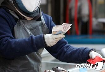 본문 이미지 - 서울 중구 남대문시장에서 한 상인이 온누리 상품권을 받고 있다. ⓒ News1 조태형 기자