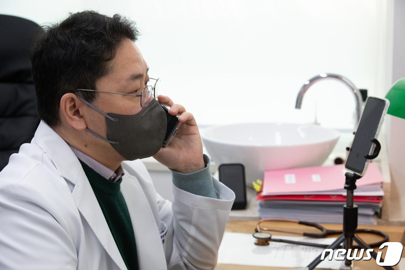 본문 이미지 - 22일 '소아전용' 의료상담센터인 서울 서초구 연세곰돌이소아청소년과의원에서 송종근 대표원장이 신종 코로나바이러스 감염증(코로나19) 재택치료 중인 소아의 보호자와 통화하며 비대면진료를 하고 있다. 2022.2.22/뉴스1 ⓒ News1 유승관 기자