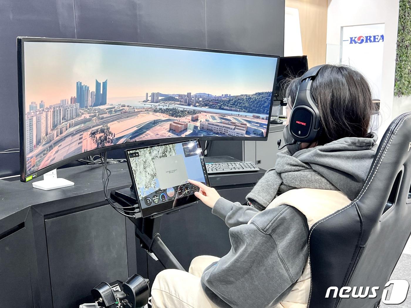 본문 이미지 - 대한항공 전시 부스를 방문한 고객이 UAM 체험존에서 시뮬레이터 조종을 하는 모습 (대한항공 제공) ⓒ 뉴스1