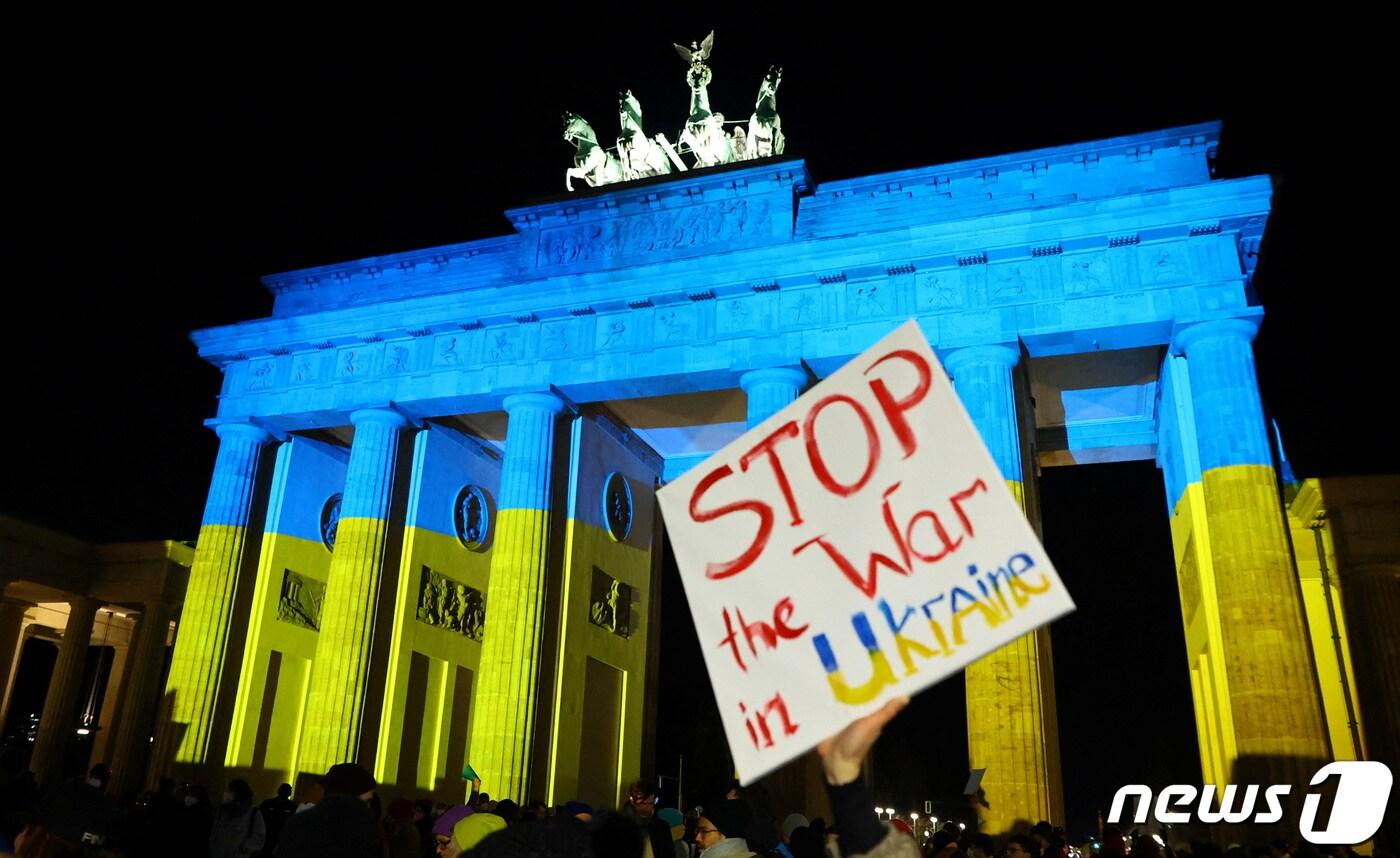 독일 브란덴부르크 문 앞에서 24일(현지시간) 시민들이 시위하고 있다. 팻말에는 "우크라이나에서 전쟁을 멈춰달라＂고 적혀있다. 2022.02.24/news1 ⓒ 로이터=뉴스1 ⓒ News1 김민수 기자