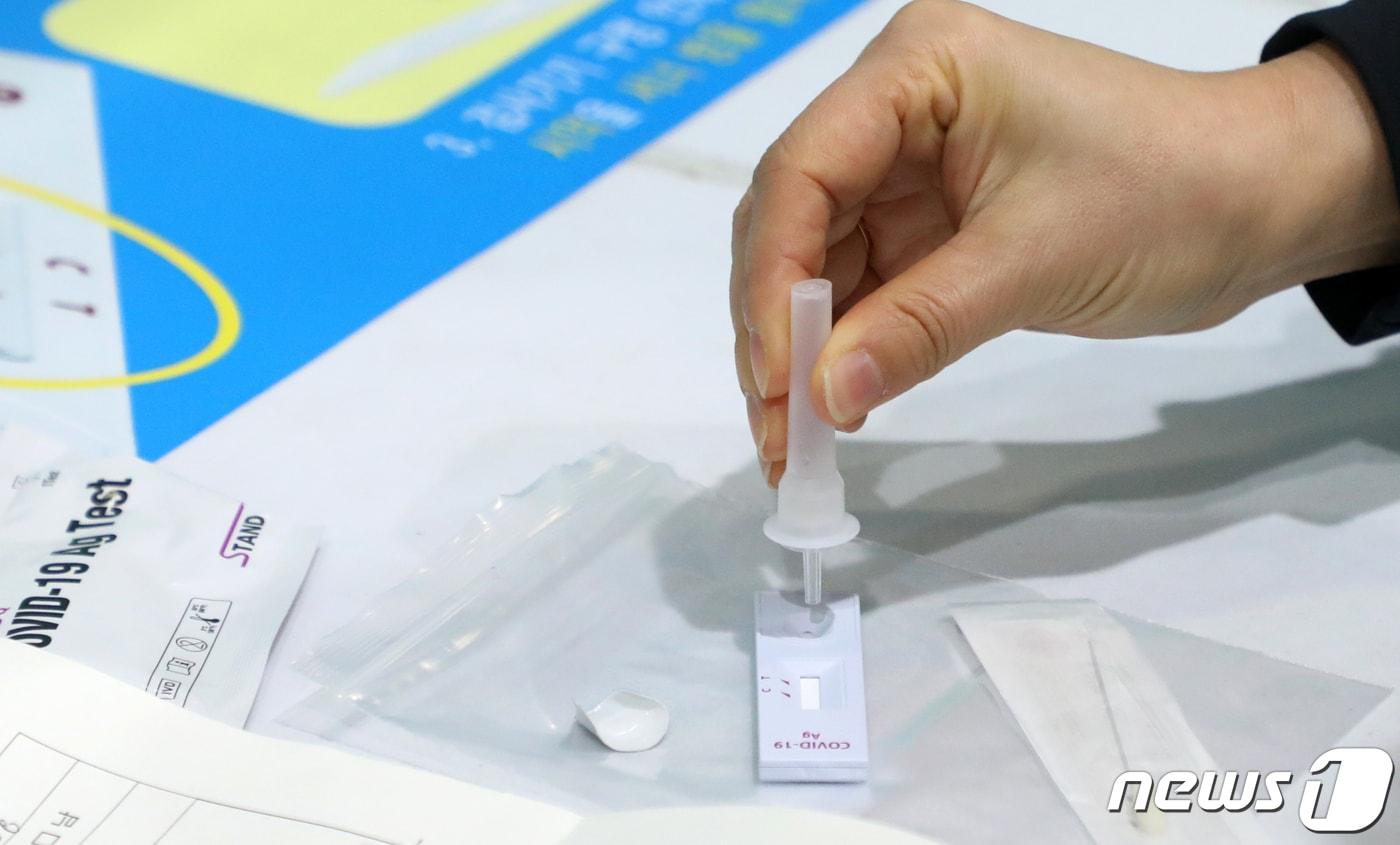본문 이미지 - 오미크론 확산 대응 방안으로 코로나19 검사·진료체계가 전면 전환된 3일 전북 전주시 화산체육관 선별진료소에서 한 시민이 자가검사키트를 이용해 신속항원검사를 하고 있다. 2022.2.3/뉴스1 ⓒ News1 유경석 기자