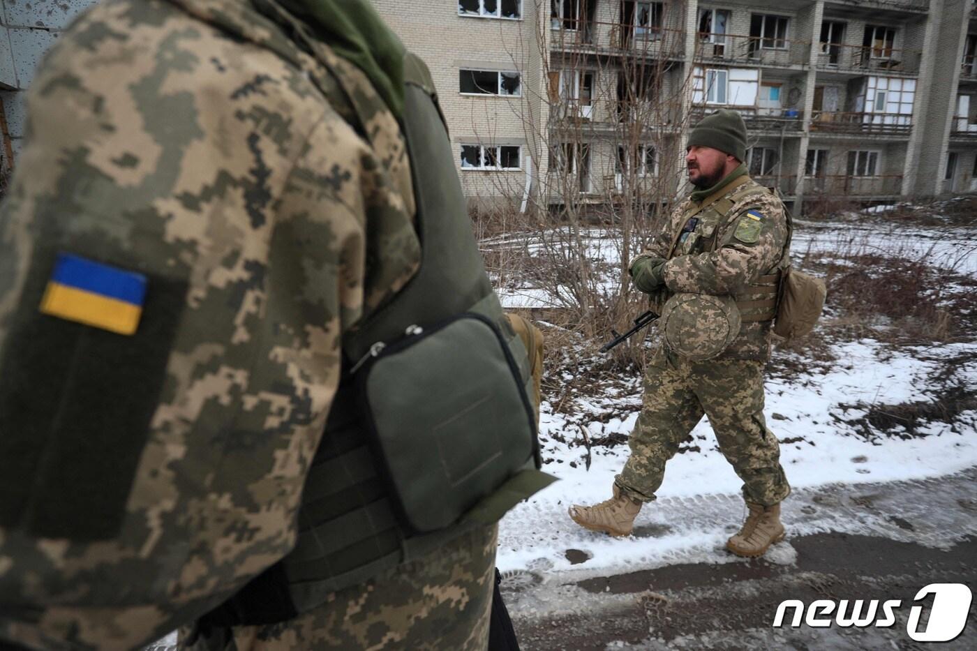 우크라이나 군인들이 2022년 2월 7일(현지시간) 도네츠크주 마린카에서 러시아의 지원을 받는 분리주의자들과 함께 파손된 건물 앞으로 걸어가고 있다. ⓒ AFP=뉴스1 ⓒ News1 김지현 기자