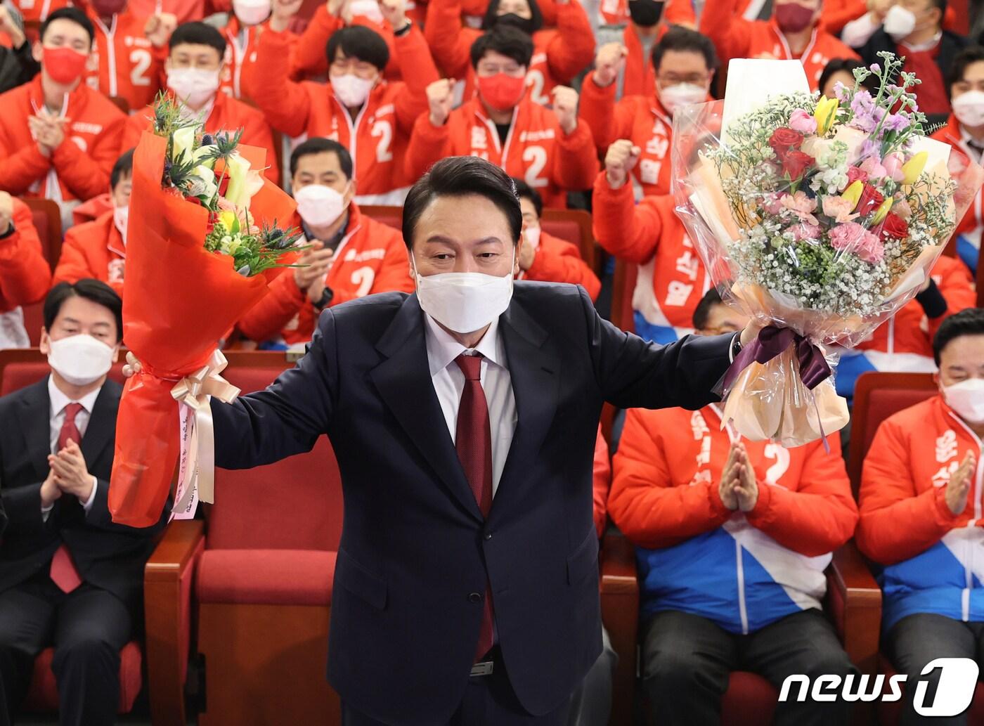 본문 이미지 - 윤석열 국민의힘 대선 후보가 10일 새벽 서울 여의도 국회 도서관에 마련된 개표상황실을 찾아 당선 축하 꽃다발을 받아 들고 있다. 2022.3.10/뉴스1 ⓒ News1 구윤성 기자