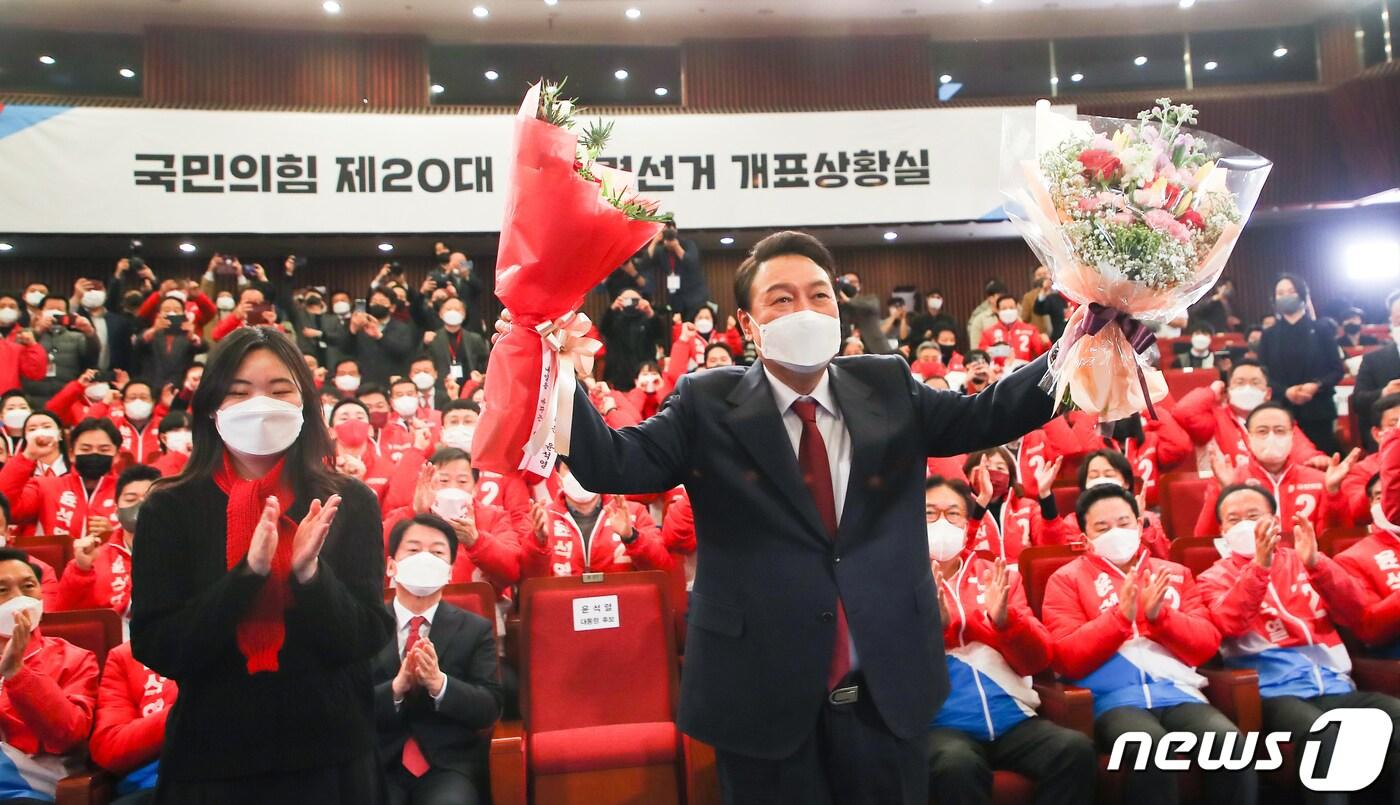 본문 이미지 - 윤석열 제20대 대통령 당선인이 10일 새벽 국회 도서관에 마련된 국민의힘 개표상황실을 찾아 축하의 꽃다발을 받아 들고 있다. 2022.3.10/뉴스1 ⓒ News1 구윤성 기자