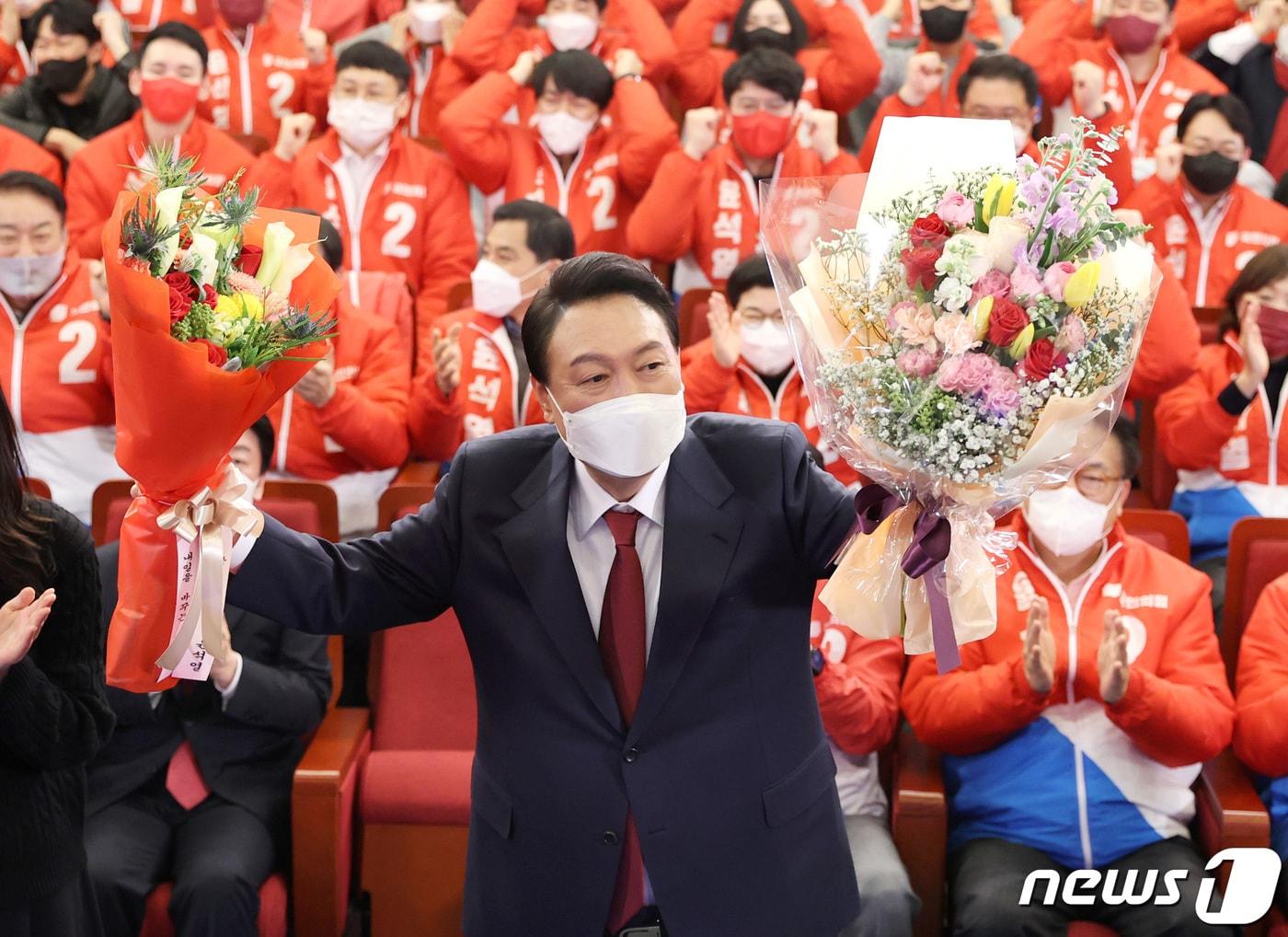 본문 이미지 - 윤석열 제20대 대한민국 대통령 당선인이 10일 새벽 서울 여의도 국회 도서관에 마련된 개표상황실을 찾아 당선 축하 꽃다발을 받아 들고 있다. 2022.3.10/뉴스1 ⓒ News1 구윤성 기자