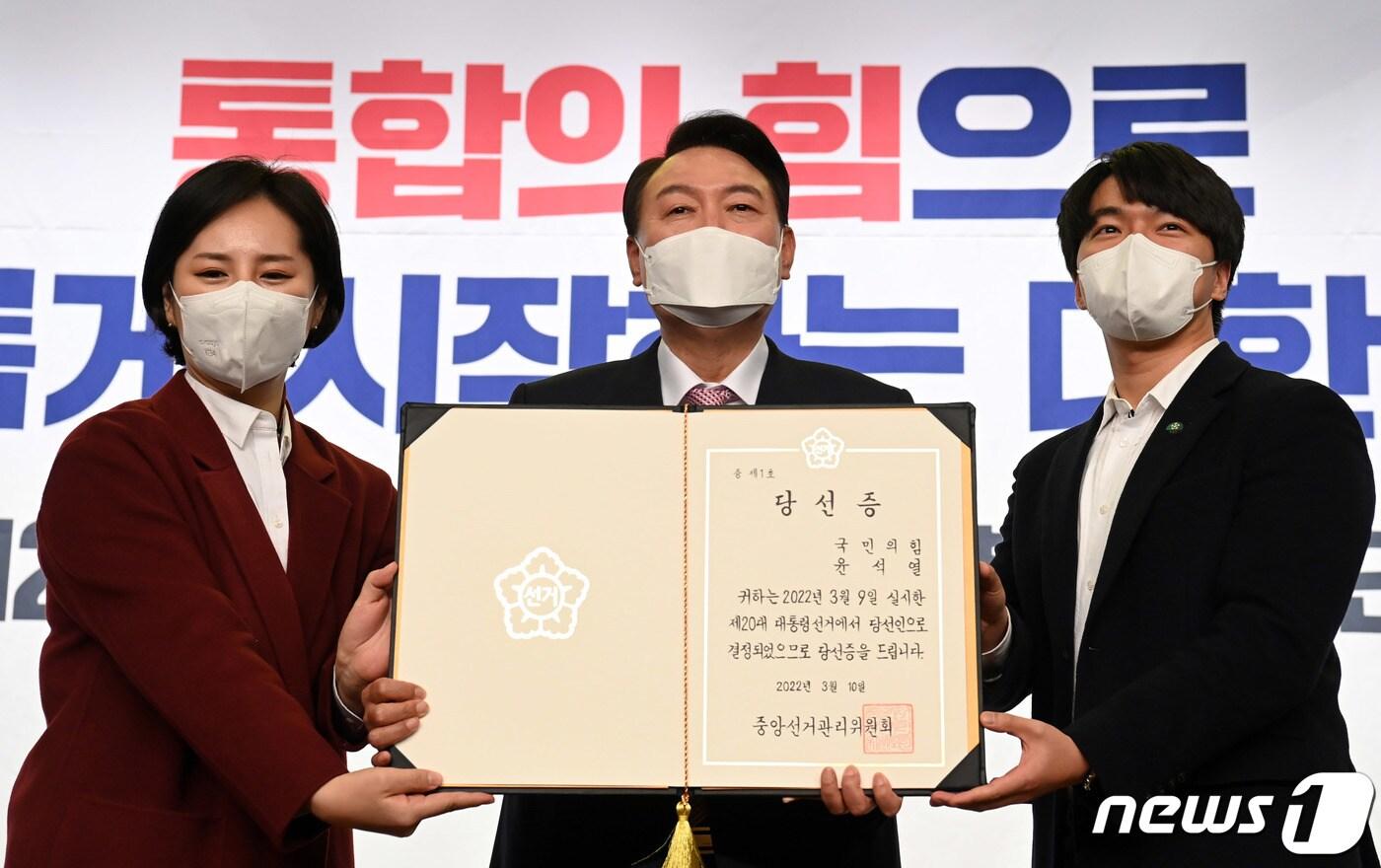 본문 이미지 - 윤석열 대통령 당선인이 10일 오후 서울 여의도 국회 도서관에서 열린 국민의힘 대선 선거대책본부 해단식에서 중앙선거관리위원회로부터 받은 당선증을 청년보좌역에게 전달받은 뒤 기념촬영을 하고 있다. 2022.3.10/뉴스1 ⓒ News1 이동해 기자