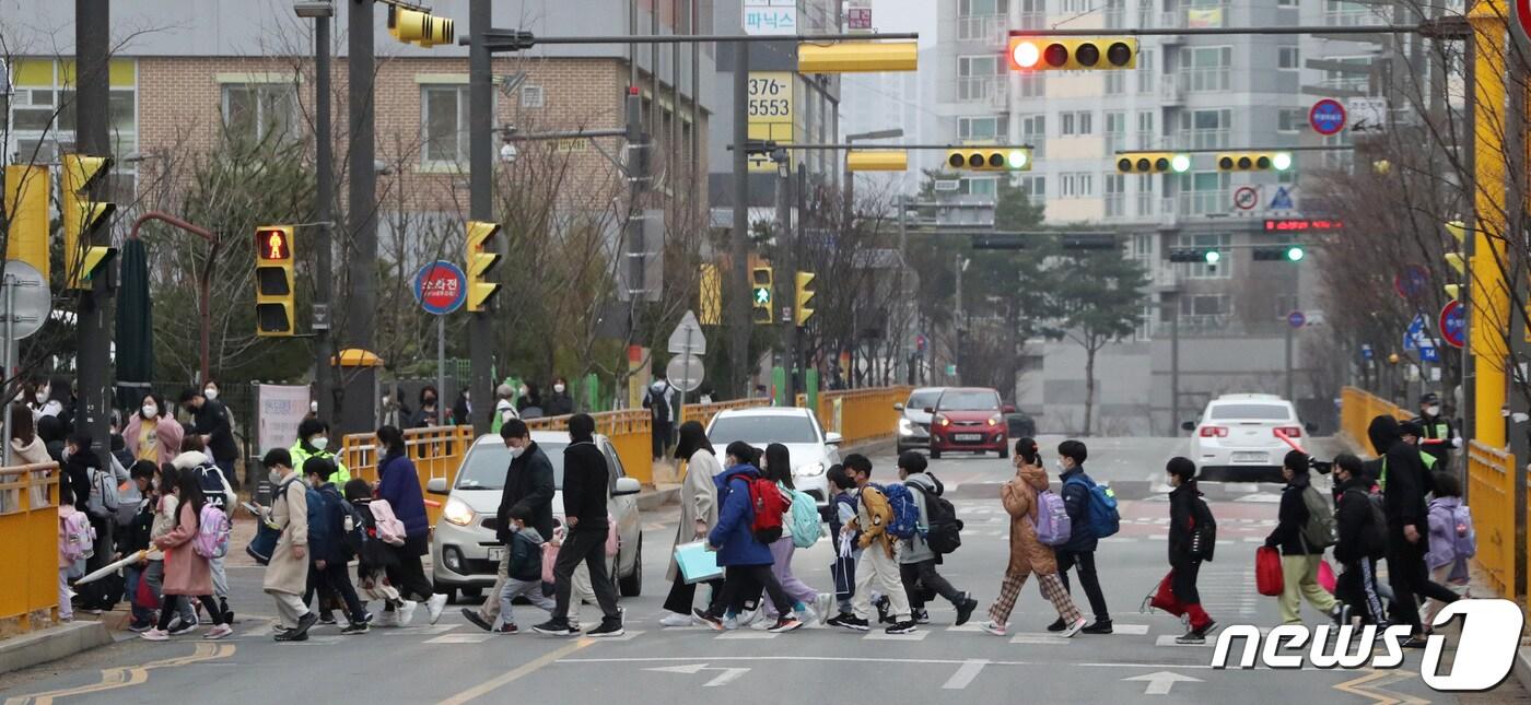 본문 이미지 - 14일 오전 경기 화성시의 한 초등학교 앞에서 아이들이 등교를 하고 있다. 이날부터 교육부와 방역당국의 '유·초·중등 및 특수학교 코로나19 감염예방 관리' 지침에 따라 동거 가족이 확진되더라도 백신 접종 유무와 관계없이 학생, 교직원의 격리가 면제된다. 2022.3.14/뉴스1 ⓒ News1 김영운 기자
