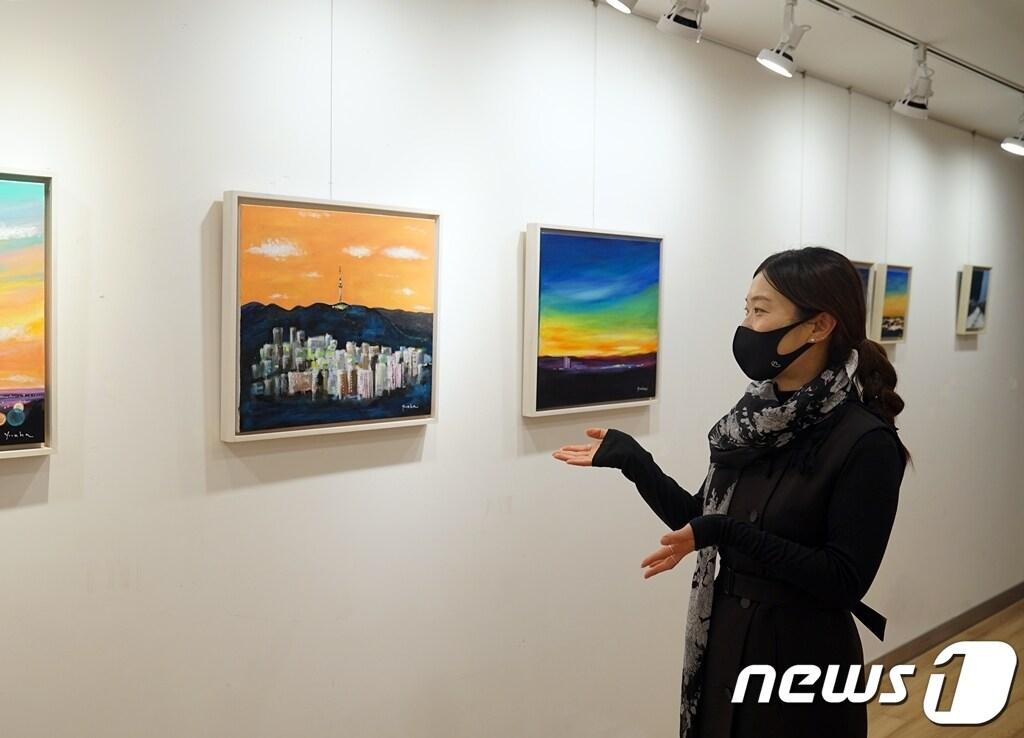 본문 이미지 - 유디치과는 4월 6일까지 서초구 소재 유디갤러리에서 서양화가 정윤하 작가(사진 속 인물)의 개인전 '희망의 빛'을 문화 사회공헌사업의 일환으로 개최한다고 14일 밝혔다. (유디치과 제공) ⓒ 뉴스1