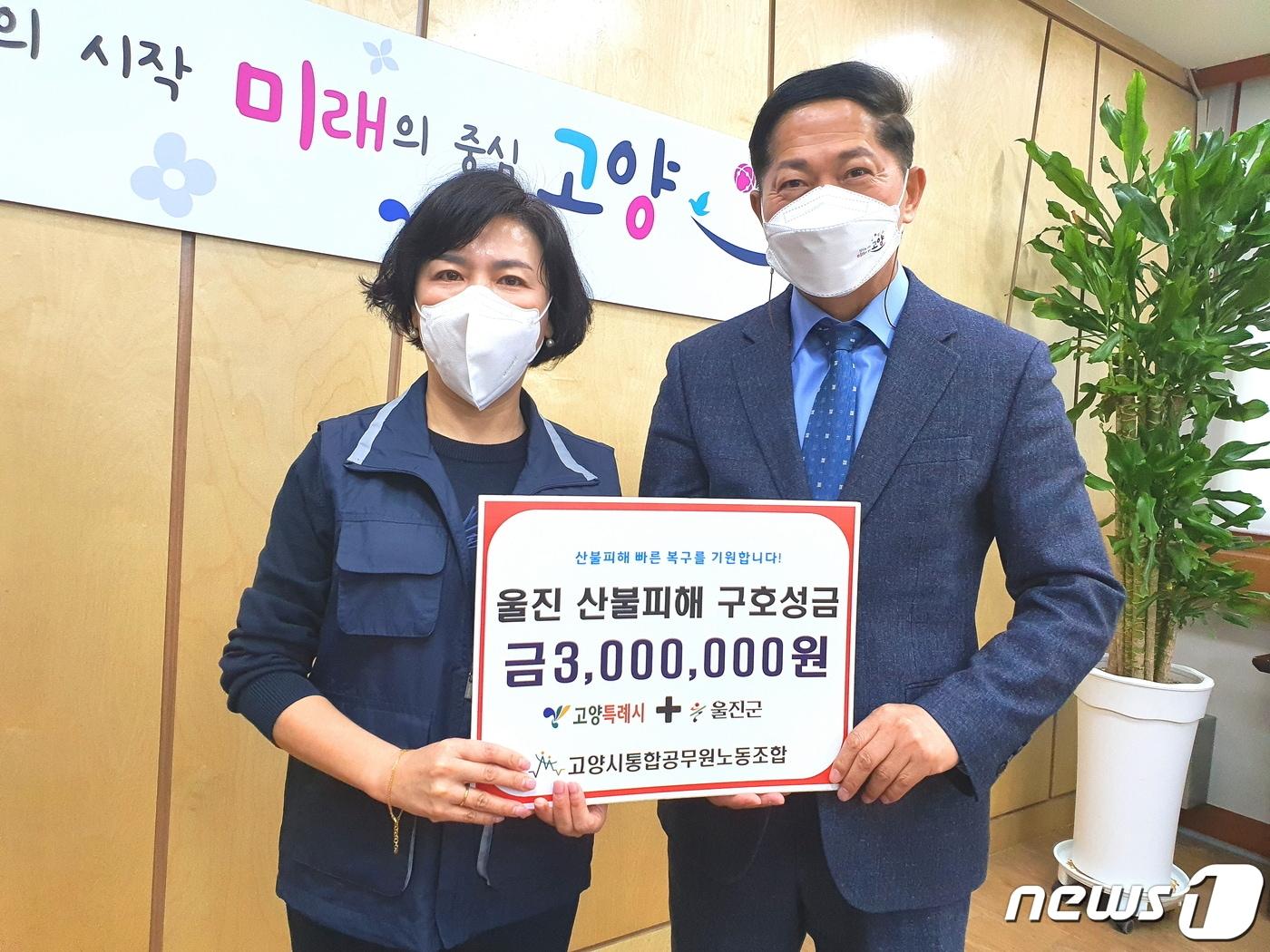 본문 이미지 - 장혜진 고양시통합공무원노조 위원장(사진 왼쪽)이 이재준 시장에게 울진 산불피해 돕기 모금활동으로 모은 300만원을 전달하고 있다. (고공노 제공) ⓒ 뉴스1