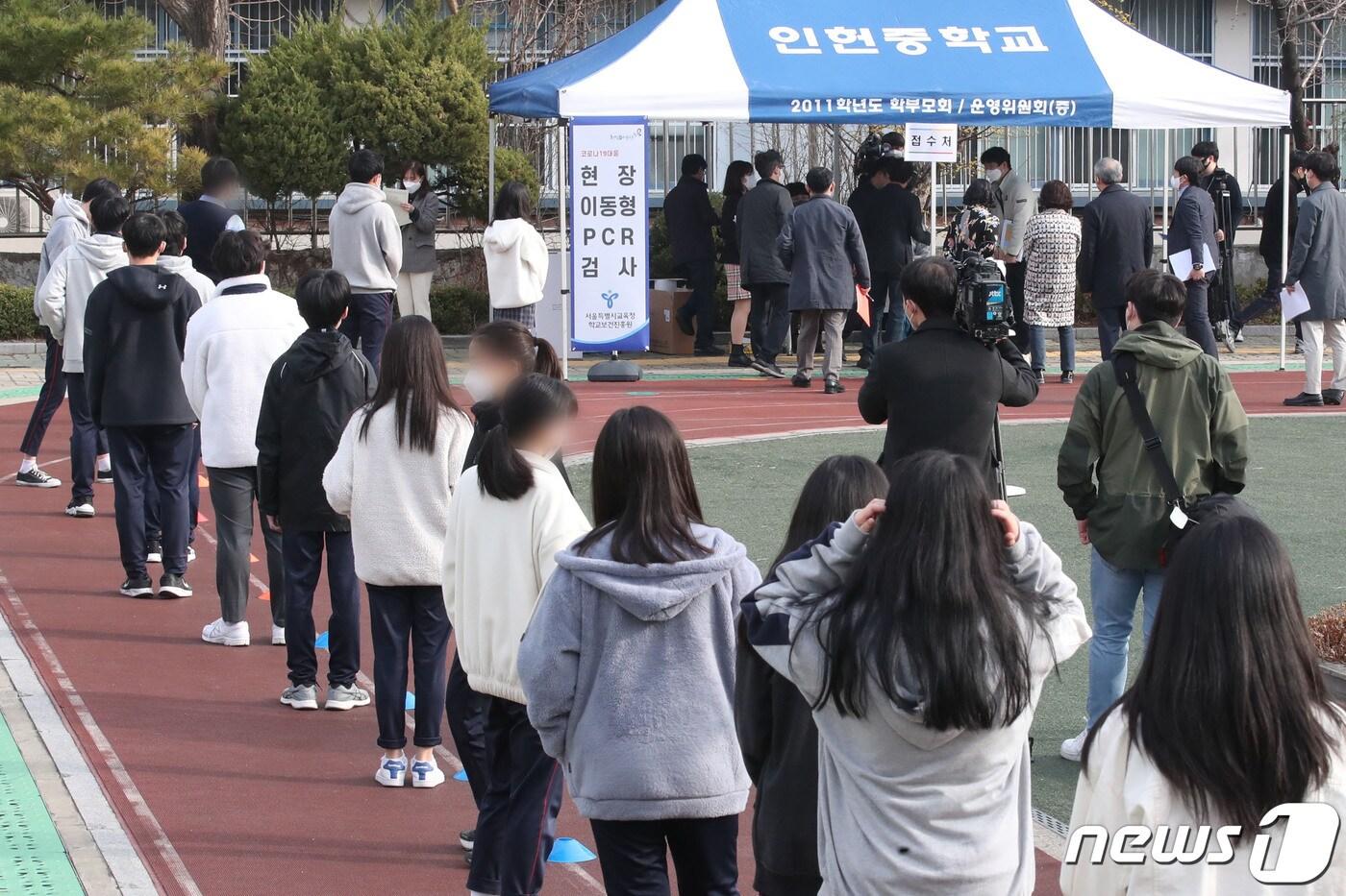 본문 이미지 - 16일 서울 관악구 인헌중학교에서 학생들이 코로나19대응 현장 이동형 PCR(유전자증폭) 검사를 받기 위해 줄 서 있다. 2022.3.16/뉴스1 ⓒ News1 황기선 기자