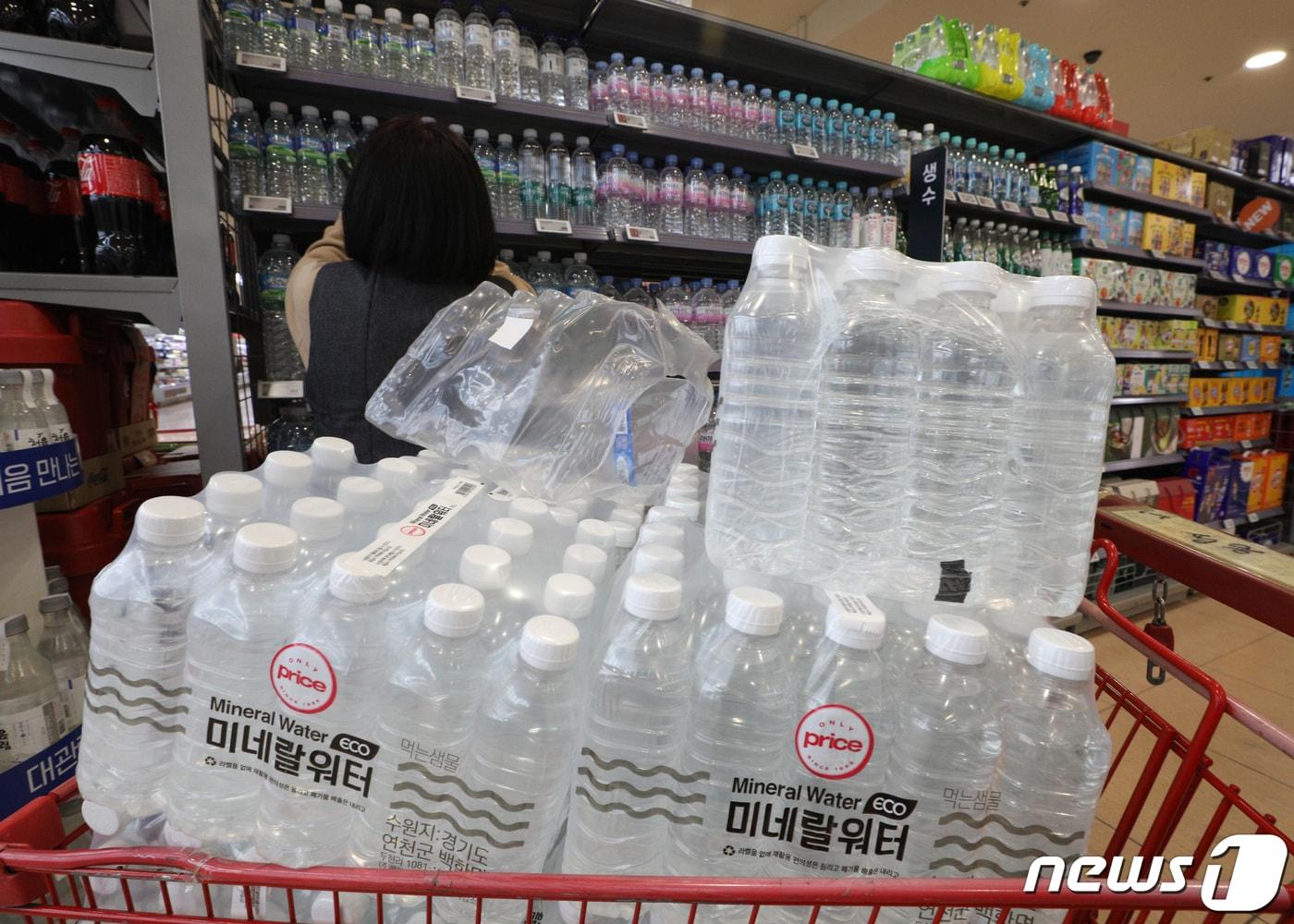 본문 이미지 - 16일 서울의 한 대형마트에서 직원이 무라벨 생수를 진열하고 있다. 롯데칠성음료는 지난해 자사 무라벨 생수 판매량이 전년 대비 1670% 증가한 2425만 상자를 기록했다고 밝혔다. 롯데칠성음료의 전체 생수 중 무라벨 생수가 차지하는 비중은 2020년 2%에서 2021년에는 32%로 증가했다. 2022.3.16/뉴스1 ⓒ News1 신웅수 기자